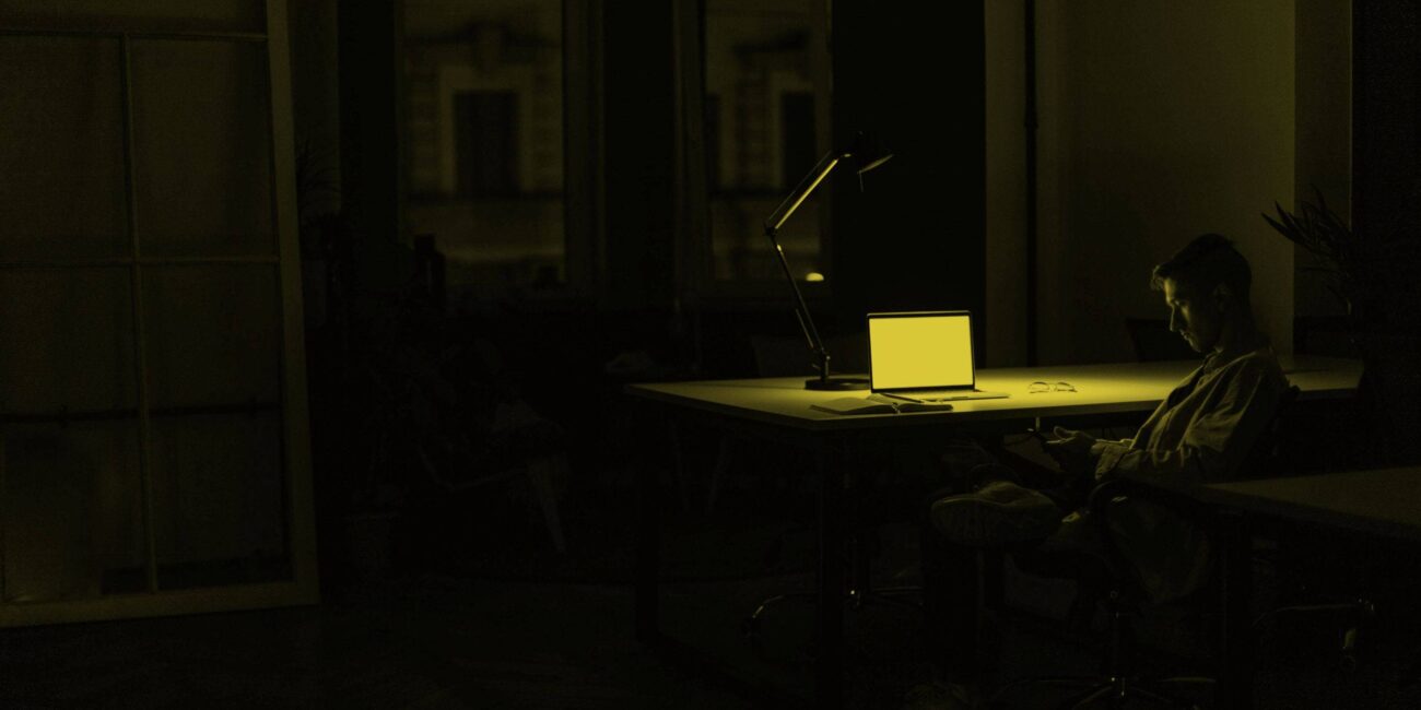 Man sitting at desk under lamp thinking about PR