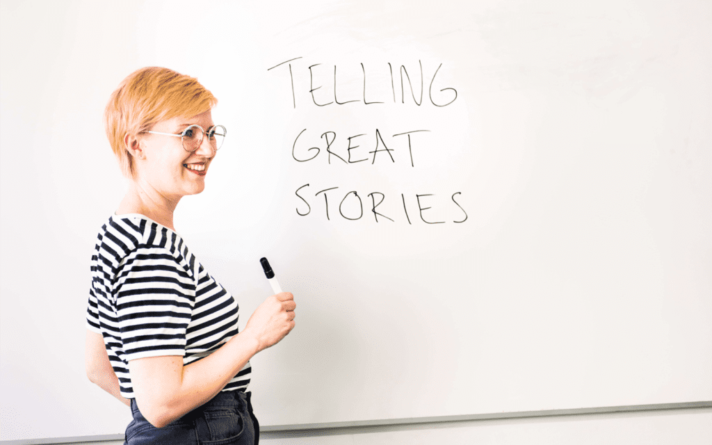 Whiteboard that reads "telling great stories" with Nina Enroth standing in front